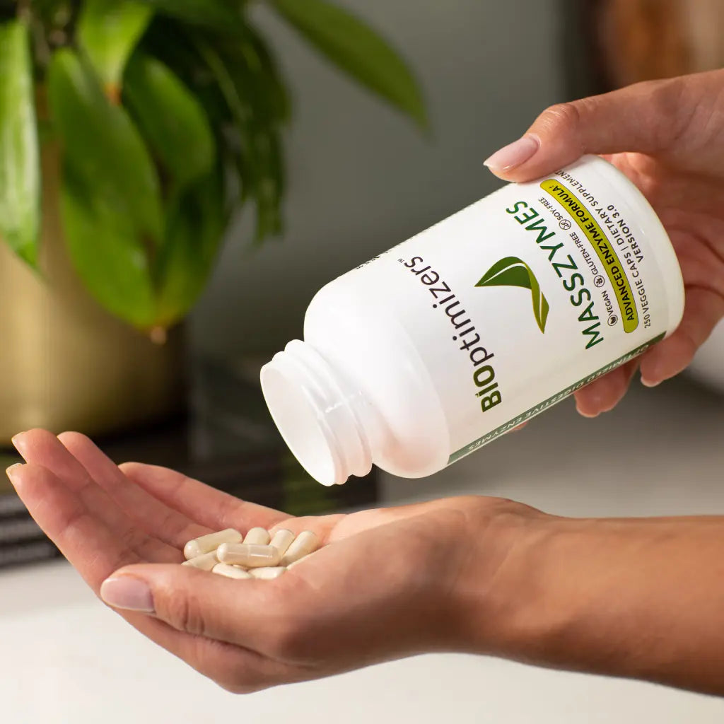 Bioptimizers Masszymes Advanced Enzyme Formula With a hand spilling out the pills